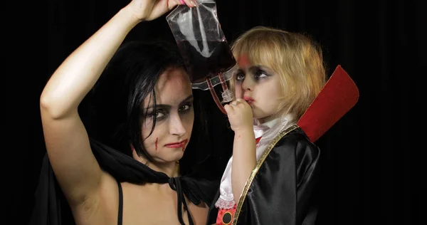 Kadın ve çocuk Dracula. Cadılar Bayramı vampir makyajı. Yüzünde kan olan çocuk. — Stok fotoğraf
