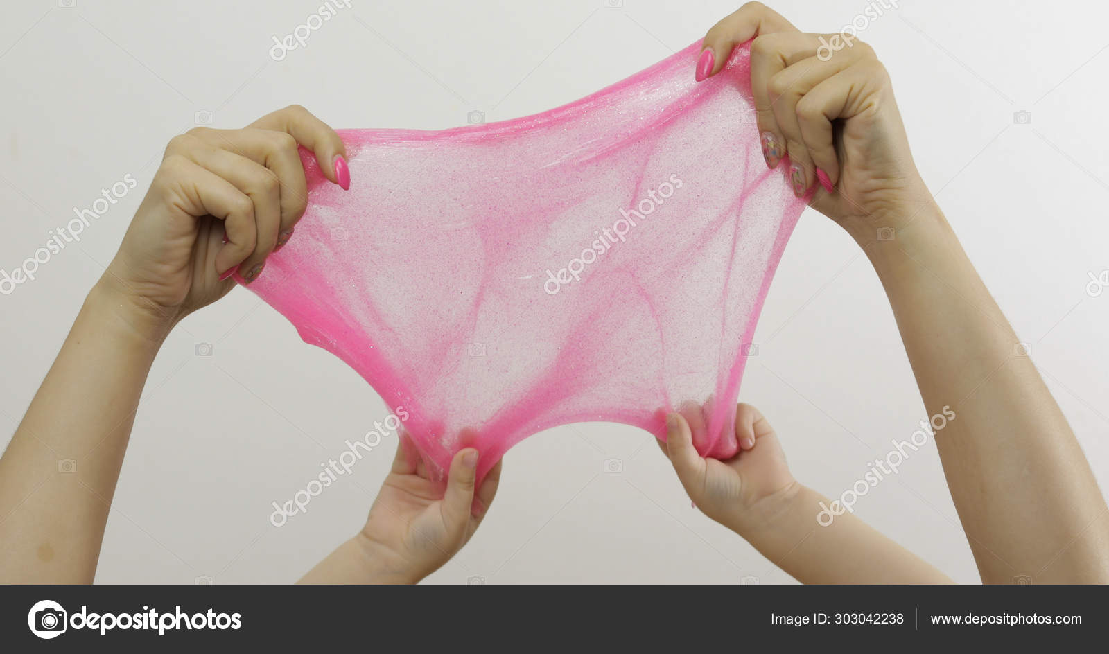 Woman and child hands playing oddly pink slime on white background.  Antistress Stock Photo by ©efurorstudio 303042238