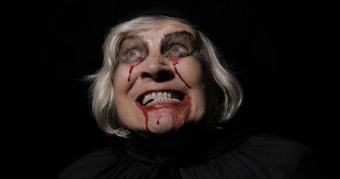 Yaşlı cadı Cadılar Bayramı makyajı. Yüzünde kan olan yaşlı kadın portresi.