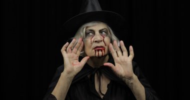 Yaşlı cadı Cadılar Bayramı makyajı. Yüzünde kan olan yaşlı kadın portresi.