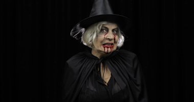 Yaşlı cadı Cadılar Bayramı makyajı. Yüzünde kan olan yaşlı kadın portresi.