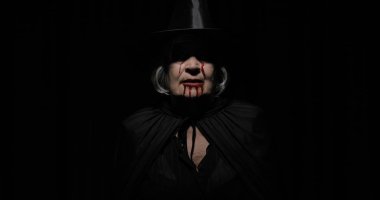 Yaşlı cadı Cadılar Bayramı makyajı. Yüzünde kan olan yaşlı kadın portresi.