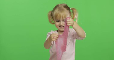 El yapımı oyuncak balçıkla oynayan çocuk. Pembe balçık yaparken eğlenen çocuk