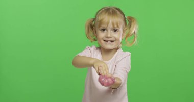 El yapımı oyuncak balçıkla oynayan çocuk. Pembe balçık yaparken eğlenen çocuk