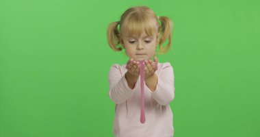 El yapımı oyuncak balçıkla oynayan çocuk. Pembe balçık yaparken eğlenen çocuk