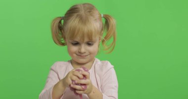 El yapımı oyuncak balçıkla oynayan çocuk. Pembe balçık yaparken eğlenen çocuk