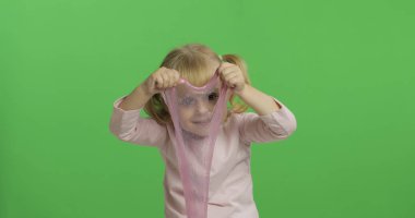 El yapımı oyuncak balçıkla oynayan çocuk. Pembe balçık yaparken eğlenen çocuk