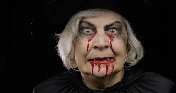 Old witch Halloween makeup. Elderly woman portrait with blood on her face. — Stock Photo, Image