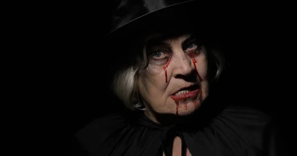 Old witch Halloween makeup. Elderly woman portrait with blood on her face. — Stock Photo, Image