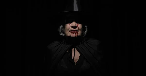 Παλιά μάγισσα μακιγιάζ αποκριών. Ηλικιωμένη γυναίκα πορτρέτο με αίμα στο πρόσωπό της. — Φωτογραφία Αρχείου