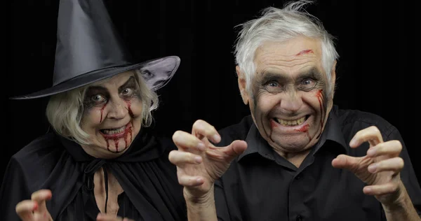 Elderly man and woman in Halloween costumes. Witch and zombie — Stock Photo, Image