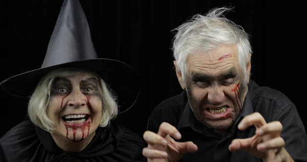 Elderly man and woman in Halloween costumes. Witch and zombie — Stock Photo, Image