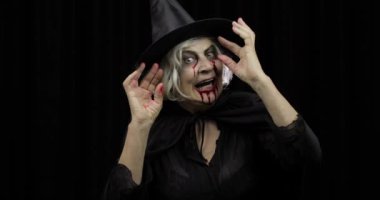 Yaşlı cadı Cadılar Bayramı makyajı. Yüzünde kan olan yaşlı kadın portresi.