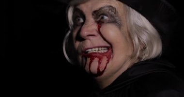 Yaşlı cadı Cadılar Bayramı makyajı. Yüzünde kan olan yaşlı kadın portresi.