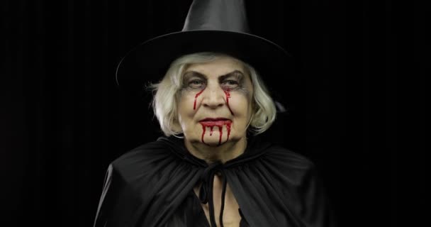 Παλιά μάγισσα μακιγιάζ αποκριών. Ηλικιωμένη γυναίκα πορτρέτο με αίμα στο πρόσωπό της. — Αρχείο Βίντεο