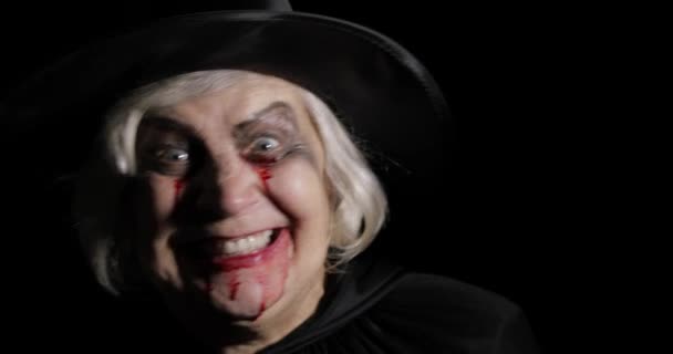 Old witch Halloween makeup. Elderly woman portrait with blood on her face. — Stock Video