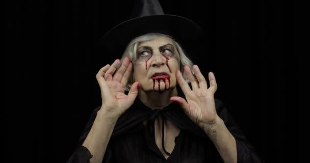 Old witch Halloween makeup. Elderly woman portrait with blood on her face. — Stock Video