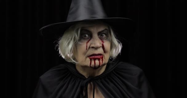 Maquiagem de bruxa velha Halloween. Mulher idosa retrato com sangue no rosto . — Vídeo de Stock