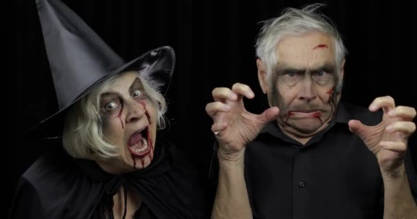 Пожилые мужчины и женщины в костюмах на Хэллоуин. Ведьма и зомби — стоковое видео