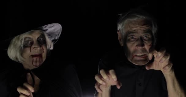 Пожилые мужчины и женщины в костюмах на Хэллоуин. Ведьма и зомби — стоковое видео