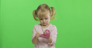 El yapımı oyuncak balçıkla oynayan çocuk. Pembe balçık yaparken eğlenen çocuk