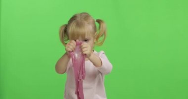 El yapımı oyuncak balçıkla oynayan çocuk. Pembe balçık yaparken eğlenen çocuk