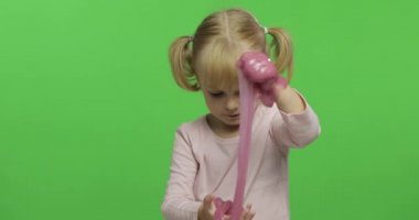 El yapımı oyuncak balçıkla oynayan çocuk. Pembe balçık yaparken eğlenen çocuk
