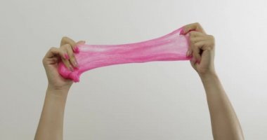 Kadın elleri beyaz arka plan üzerinde garip tatmin edici pembe balçık oynuyor. Antistres