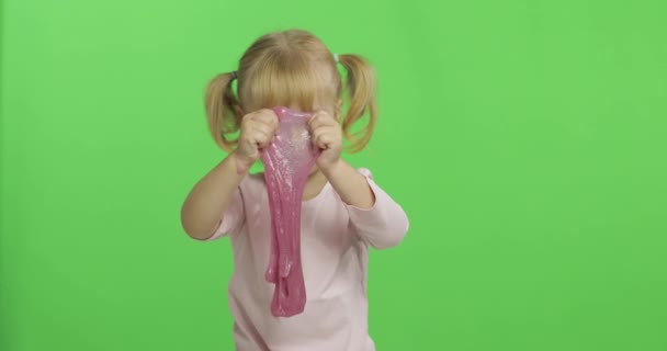 Criança brincando com lodo de brinquedo feito à mão. Criança se divertindo fazendo lodo rosa — Vídeo de Stock