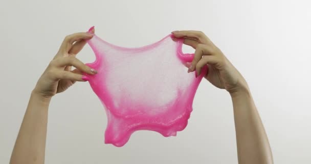 Руки жінки грають дивно задовольняючи рожевий слиз на білому тлі. антистрес — стокове відео
