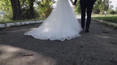 Parkta yürüyen gelinli damat. Düğün çifti. Mutlu bir aile. Newlyweds