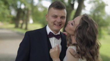 Beyaz damat ve gelin parkta gülüyor. Düğün çifti. Mutlu yeni evliler