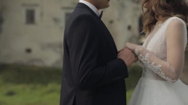 Eski kale duvarının yanında gelinli beyaz damat. Düğün çifti. Mutlu yeni evliler