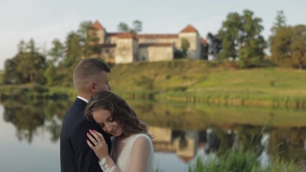 Novio caucásico con novia en el parque cerca del lago. Pareja de bodas. Recién casados beso — Vídeo de stock