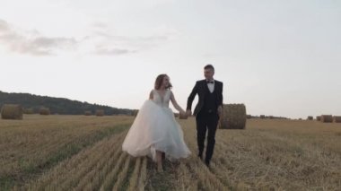 Damat ve gelin tarlada yürüyor. Düğün çifti. Mutlu yeni evliler