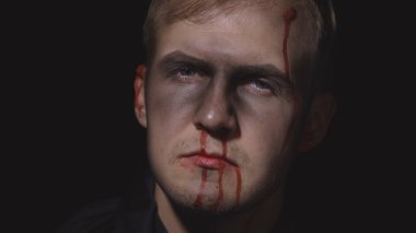 Cadılar Bayramı erkek portresi. Yüzünden kan damlayan bir adam. Korkunç makyaj.