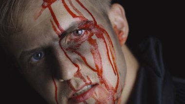 Cadılar Bayramı erkek portresi. Yüzünden kan damlayan bir adam. Korkunç makyaj.