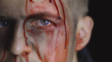 Cadılar Bayramı erkek portresi. Yüzünden kan damlayan bir adam. Korkunç makyaj.