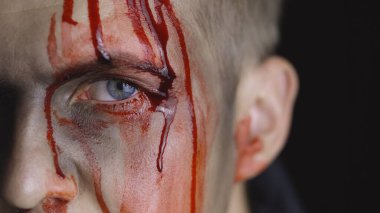Cadılar Bayramı erkek portresi. Yüzünden kan damlayan bir adam. Korkunç makyaj.