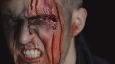 Cadılar Bayramı erkek portresi. Yüzünden kan damlayan bir adam. Korkunç makyaj.