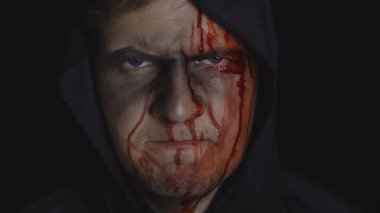 Adam cellat Cadılar Bayramı makyajı ve kostümü. Yüzünde kan olan bir adam.