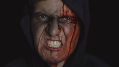 Adam cellat Cadılar Bayramı makyajı ve kostümü. Yüzünde kan olan bir adam.