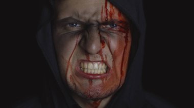 Adam cellat Cadılar Bayramı makyajı ve kostümü. Yüzünde kan olan bir adam.