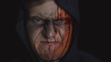 Adam cellat Cadılar Bayramı makyajı ve kostümü. Yüzünde kan olan bir adam.
