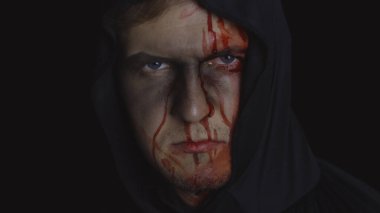 Adam cellat Cadılar Bayramı makyajı ve kostümü. Yüzünde kan olan bir adam.