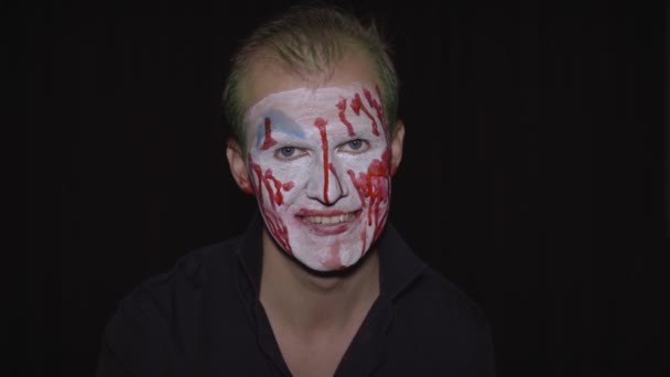 Clown Halloween uomo ritratto. Faccia di sangue da clown inquietanti e malvagi. Trucco viso bianco — Video Stock