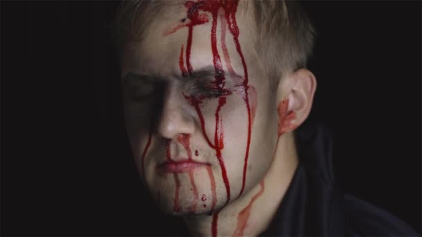 Retrato de Halloween. Un tipo con sangre goteando en su cara. Maquillaje aterrador — Vídeo de stock