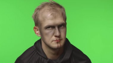 Adam cellat Cadılar Bayramı makyajı ve kostümü. Yüzünde kan olan bir adam.