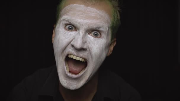 Retrato de hombre payaso Halloween. Primer plano de una cara de payasos malvados. Maquillaje de cara blanca — Vídeo de stock