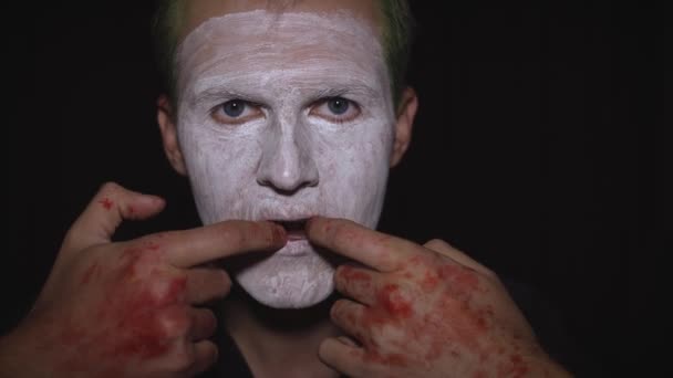 Portret klauna Halloween. Zbliżenie na twarz złego klauna. Biały makijaż twarzy — Wideo stockowe